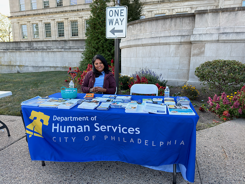 Woman sitting at Dept. of Human Services booth