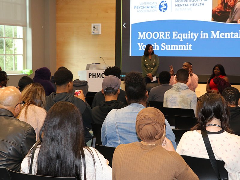 Audience listens as panelists speak at the Moore Equity in Mental Health Youth Summit in a conference room
