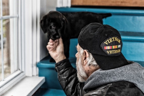a veteran reaching out to his puppy