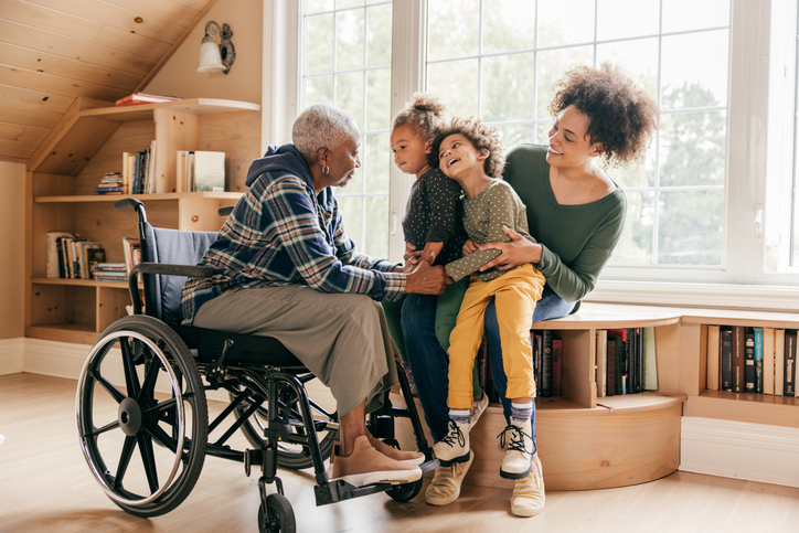 Daughter and grandchildren with grandparent in wheelchair