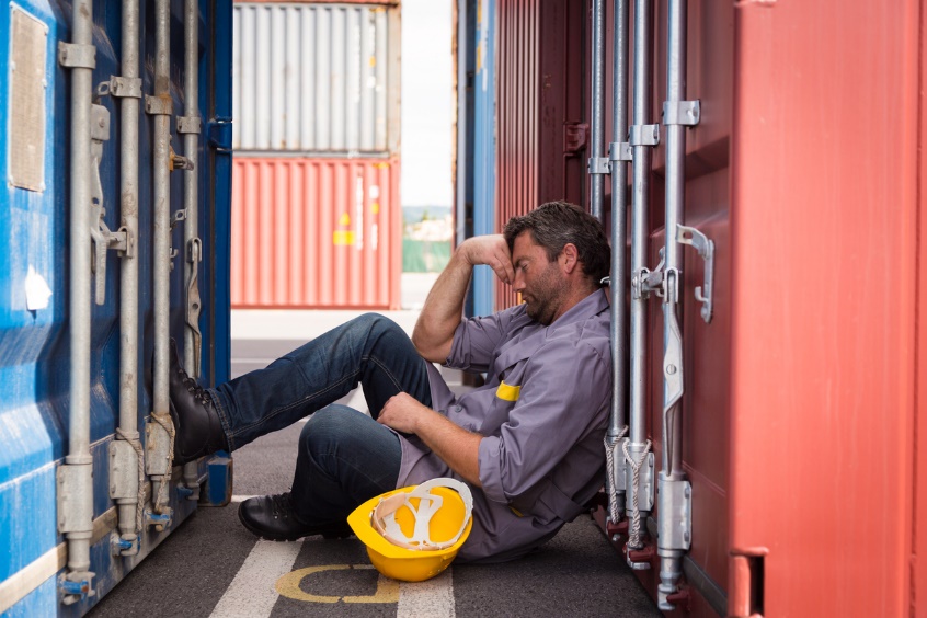 A person sitting in front of a door Description automatically generated