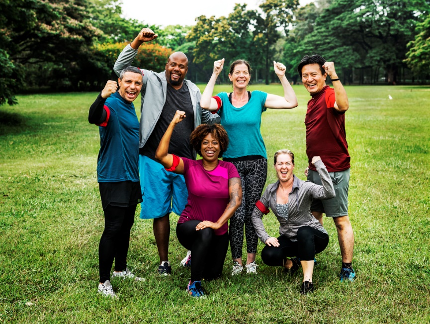 A group of people standing on top of a grass covered field Description automatically generated