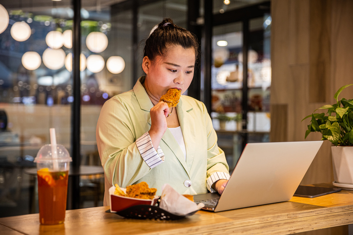 woman working on a computer and eating
