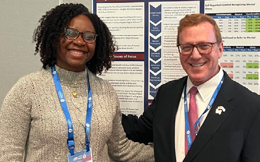 Dr. Atasha Jordan poseswith Dr. Saul Levin in front of her poster presentation at the 2023 Annual Meeting
