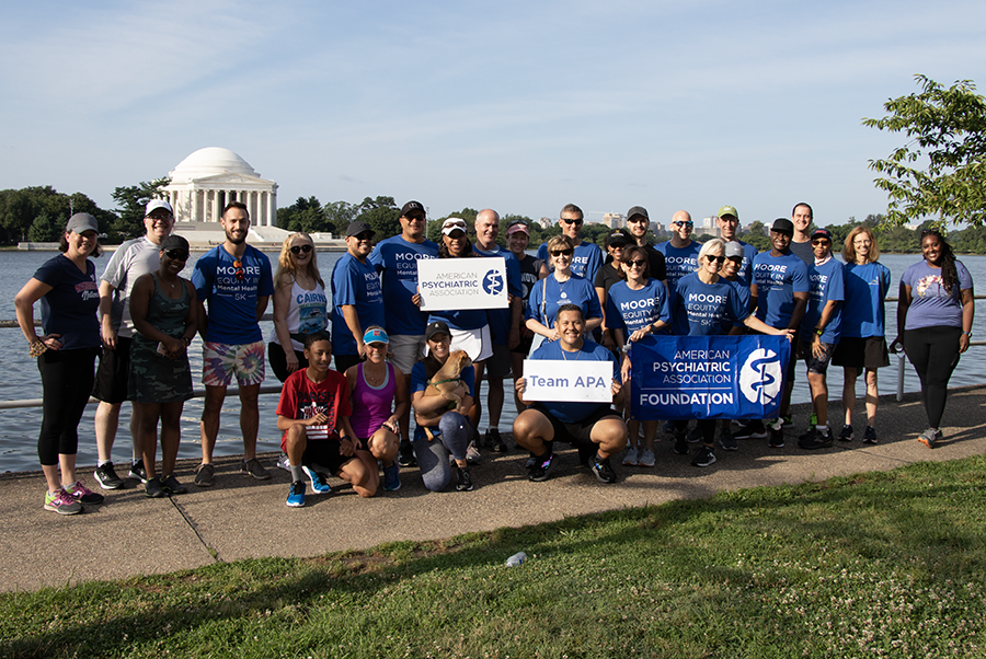 Past 5K participants posing with encouraging signs