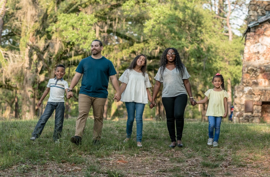 A group of people standing next to a tree Description automatically generated