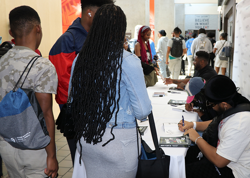 participants at the Youth Summit wait for autographed copies of Jay Barnett's book