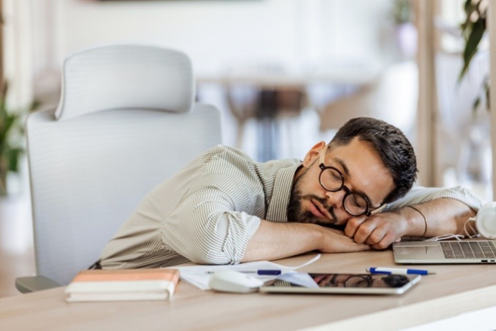 man falling asleep at desk