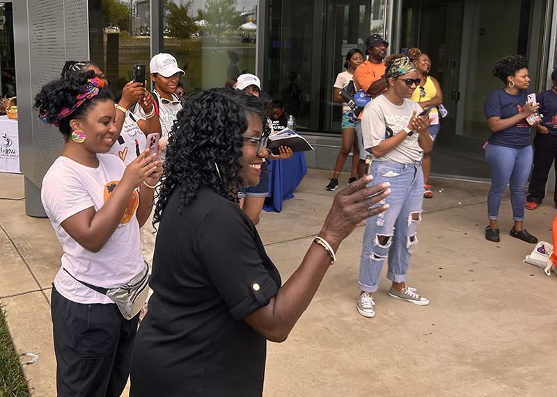 participants applaud a speaker at the community fair